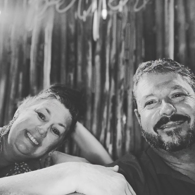 Nikki and Gunny smiling together in a black and white photo