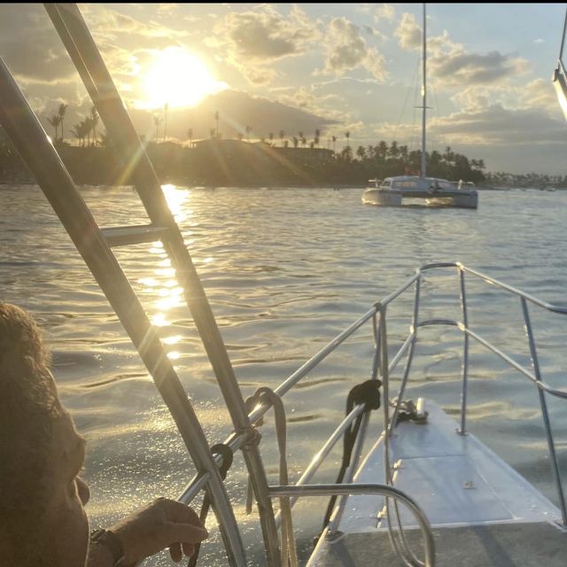 Sunset from the bow of a catamaran, with palm trees along the shore