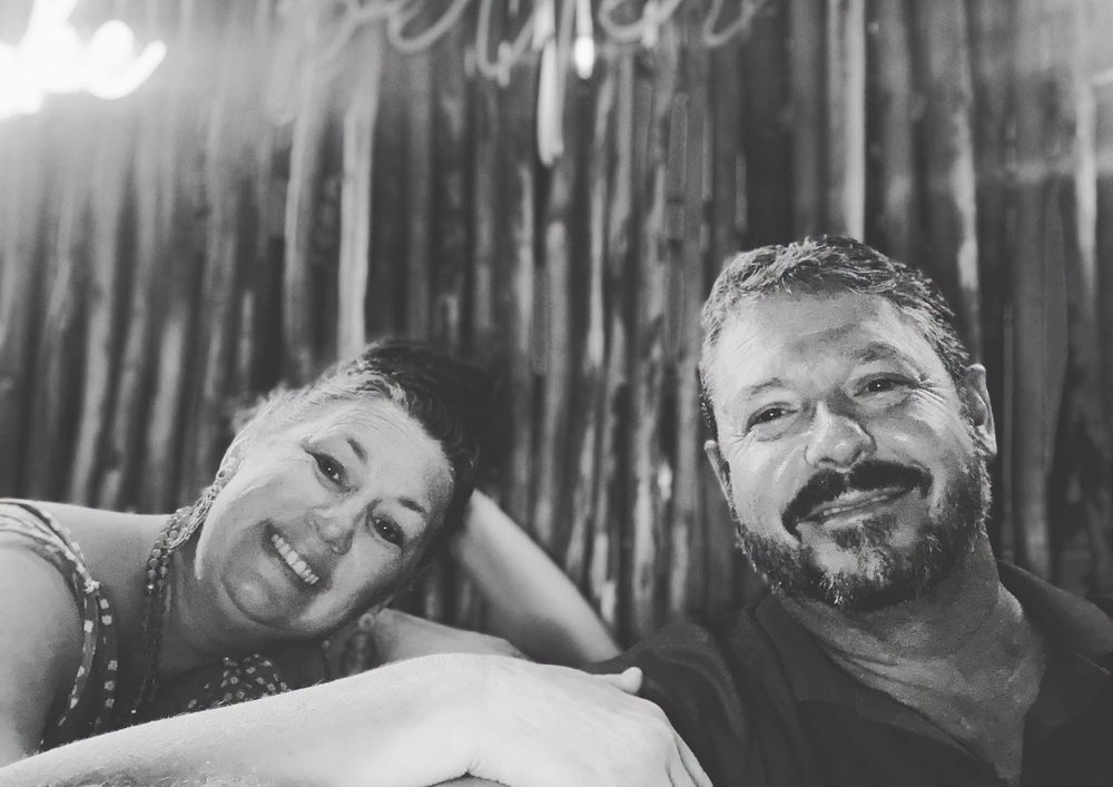 Nikki and Gunny smiling together in a black and white photo