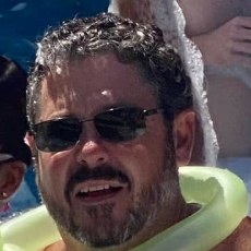 Gunny grinning in the foam with a balloon ring around his neck