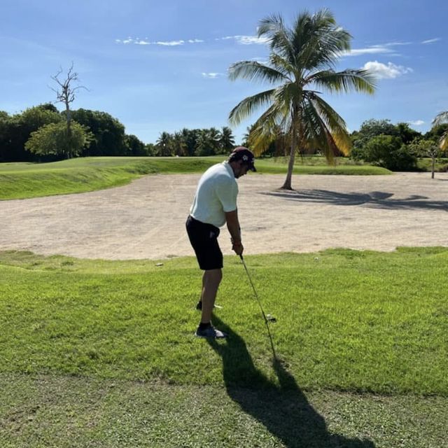 Gunny lining up a shot beside a bunker under a palm tree