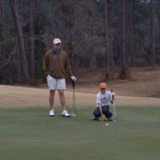 Gunny watching as a young golfer lines up a putt