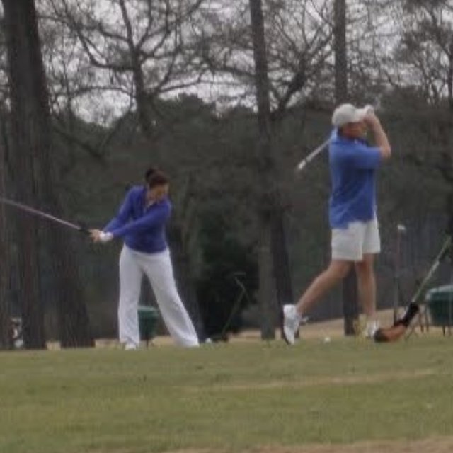 Nikki and her son mid-swing side by side on a driving range